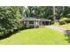 Attractive single-story brick house with an attached carport, surrounded by a lush, green lawn and mature trees at 2044 Wilandrew Dr, Decatur, GA 30033