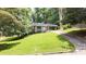 Attractive single-story brick house with an attached carport, surrounded by a lush, green lawn and mature trees at 2044 Wilandrew Dr, Decatur, GA 30033