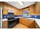 Close-up view of a kitchen with wood cabinets, blue backsplash, and stainless steel appliances at 2044 Wilandrew Dr, Decatur, GA 30033