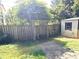 Private fenced backyard area with mature trees, gate, and shed offers secluded outdoor space at 1244 Hickory Wood Ne Dr, Woodstock, GA 30188