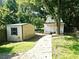 Backyard including a small shed with siding and a cottage-style house with white siding and a porch at 1244 Hickory Wood Ne Dr, Woodstock, GA 30188