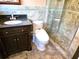 Bathroom featuring tile flooring, dark vanity, toilet and glass door shower at 1244 Hickory Wood Ne Dr, Woodstock, GA 30188