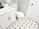 Updated bathroom with white vanity, toilet, and patterned tile floor at 1244 Hickory Wood Ne Dr, Woodstock, GA 30188