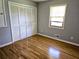 Bedroom with wood flooring, window with blind and closet with folding doors at 1244 Hickory Wood Ne Dr, Woodstock, GA 30188
