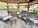 Interior view of a gazebo with wicker furniture including chairs, sofa, and a table with a decorative rug at 1244 Hickory Wood Ne Dr, Woodstock, GA 30188
