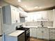 Modern kitchen features white cabinets, stainless steel appliances, stylish countertops and backsplash at 1244 Hickory Wood Ne Dr, Woodstock, GA 30188