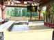 Gazebo featuring an outdoor kitchen with a stainless steel grill, countertop space, and ceiling fans and a mounted TV at 1244 Hickory Wood Ne Dr, Woodstock, GA 30188