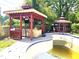 Pool area featuring a gazebo with an outdoor kitchen and another closed gazebo for relaxing by the pool at 1244 Hickory Wood Ne Dr, Woodstock, GA 30188