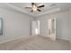 Bright bedroom showcasing a ceiling fan, tray ceiling, and open doorways at 15 Parkside Vw, Cartersville, GA 30121