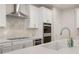 Modern kitchen with white cabinets, stainless steel appliances, quartz countertops, and tiled backsplash at 15 Parkside Vw, Cartersville, GA 30121