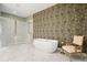 Bright bathroom featuring a freestanding tub, patterned wallpaper, and marble flooring at 1598 Aldworth Se Pl, Marietta, GA 30067