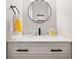Stylish bathroom with a marble countertop, modern faucet, and sleek, round mirror at 1770 Laurel Creek Dr, Lawrenceville, GA 30043