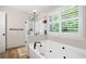 Relaxing bathroom featuring a soaking tub, separate glass shower, and bright natural light at 1770 Laurel Creek Dr, Lawrenceville, GA 30043