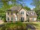 Charming two-story home featuring a well-manicured lawn, complemented by lush, mature trees providing ample shade at 1770 Laurel Creek Dr, Lawrenceville, GA 30043