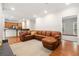 Spacious living room with an open layout, leather sectional, and seamless transition to the kitchen area at 1770 Laurel Creek Dr, Lawrenceville, GA 30043