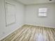Bright bedroom with wood-look flooring, white walls, and two windows offering natural light at 3045 Revere Cir, Snellville, GA 30039