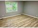 Well-lit bedroom featuring a window and stylish wood-look flooring, and neutral walls at 3045 Revere Cir, Snellville, GA 30039