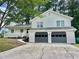 Inviting two-story home with a two-car garage, white siding, a covered porch, and mature trees at 3045 Revere Cir, Snellville, GA 30039