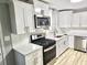 Modern kitchen with white cabinets, stainless steel appliances, quartz countertops, and subway tile backsplash at 3045 Revere Cir, Snellville, GA 30039