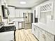 Modern kitchen featuring white cabinets, stainless steel appliances, quartz countertops, and luxury vinyl plank flooring at 3045 Revere Cir, Snellville, GA 30039