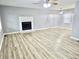 Bright, open living room with gray walls, white trim, a fireplace, ceiling fan, and vinyl plank flooring at 3045 Revere Cir, Snellville, GA 30039