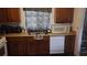 Galley kitchen with wooden cabinets, stainless steel sink, and a white dishwasher at 335 Chase Woods Cir, Jonesboro, GA 30236