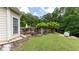 Picturesque backyard setting featuring a wooden deck, stone patio, and mature trees at 11440 Azalea Trl, Hampton, GA 30228