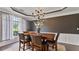 Charming dining room featuring a wooden table, four chairs, and natural light from a nearby window at 11440 Azalea Trl, Hampton, GA 30228