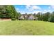 Beautiful front exterior view of the home with a manicured lawn and mature trees at 11440 Azalea Trl, Hampton, GA 30228