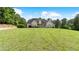 Beautiful front exterior view of the home with a manicured lawn and mature trees at 11440 Azalea Trl, Hampton, GA 30228