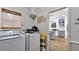 Well-lit laundry room featuring a modern washer, dryer, and shelving next to a doorway to a kitchen at 11440 Azalea Trl, Hampton, GA 30228