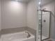 Bathroom features a soaking tub with tile backsplash, walk-in shower with glass doors and neutral paint at 1155 Park Center Cir, Austell, GA 30168