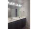 Bathroom features a double sink vanity, dark wood cabinets, light countertop, and modern fixtures at 1155 Park Center Cir, Austell, GA 30168