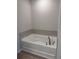 A clean, bright white bathtub with chrome fixtures and stone-like tile surround at 1155 Park Center Cir, Austell, GA 30168