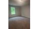 A carpeted bedroom with a window overlooking a natural, wooded landscape at 1155 Park Center Cir, Austell, GA 30168