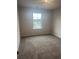 A carpeted bedroom with a window overlooking a residential street at 1155 Park Center Cir, Austell, GA 30168