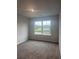 A neutrally decorated bedroom with carpet and a window facing out to new construction at 1155 Park Center Cir, Austell, GA 30168