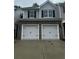 Two car garage of a two-story home with grey siding and black shutters at 1155 Park Center Cir, Austell, GA 30168