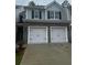 Two car garage of a two-story home with grey siding and black shutters at 1155 Park Center Cir, Austell, GA 30168