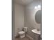 Half bathroom with pedestal sink, oval mirror, and wood look flooring at 1155 Park Center Cir, Austell, GA 30168