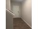 Hallway with hard surface floors next to a staircase and a white interior door at 1155 Park Center Cir, Austell, GA 30168