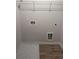 A basic laundry room setup with washer and dryer hookups and overhead wire shelving at 1155 Park Center Cir, Austell, GA 30168