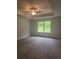 Spacious bedroom with a ceiling fan, tray ceilings, and a large window overlooking the backyard at 1155 Park Center Cir, Austell, GA 30168