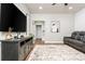 Inviting basement living room features hardwood floors, entertainment center, modern seating, and backyard views at 2024 Towneship Trl, Roswell, GA 30075