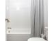 Clean white tiled tub and shower with a gray patterned shower curtain and modern brushed nickel fixtures at 2024 Towneship Trl, Roswell, GA 30075
