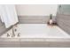 Modern white bathtub with brushed nickel fixtures and gray tile surround for a spa-like feel at 2024 Towneship Trl, Roswell, GA 30075