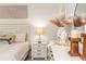 Bright bedroom featuring a well-made bed, white dresser, decorative items, and stylish neutral-toned decor at 2024 Towneship Trl, Roswell, GA 30075