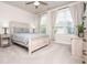 Bright bedroom with a bed with decorative pillows, bedside table, and a large window at 2024 Towneship Trl, Roswell, GA 30075