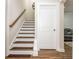 Staircase to basement featuring wood and carpeted steps and modern railing and white risers and stringers at 2024 Towneship Trl, Roswell, GA 30075
