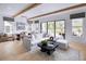 Bright open-concept living space featuring exposed wood beams, a large sliding glass door, and modern decor at 210 Mooney Rd, Woodstock, GA 30188
